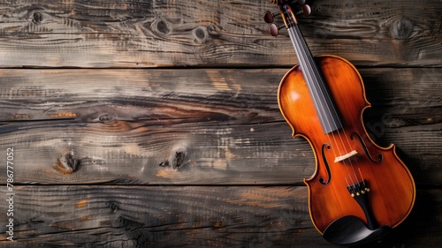 Violin rests on rustic wooden background, showcasing its rich color and curves photo
