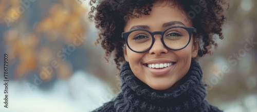 The image shows a close up of a woman wearing glasses, with a cheerful smile directed at the camera photo