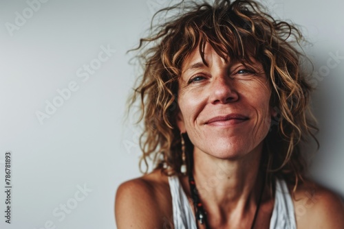 Portrait of a beautiful middle aged woman with curly hair. Studio shot.