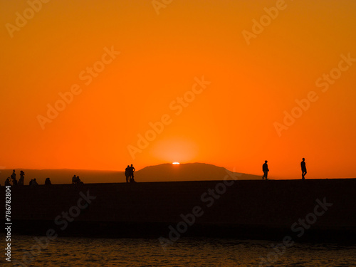 Silhouette of people in a port town at dusk  Chania  Crete  Greece 