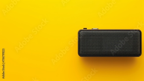 Modern portable speaker with a minimalist design, elegantly isolated on a vivid yellow background