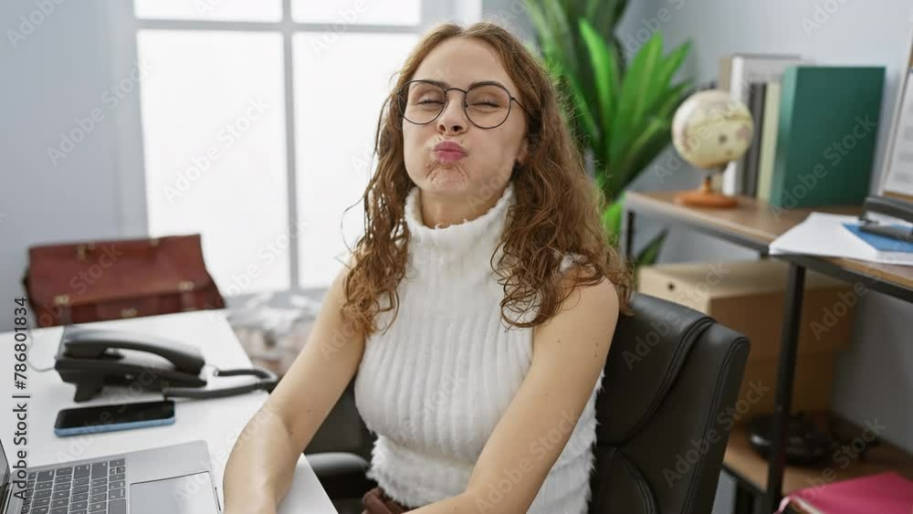 Hilarious beautiful young woman working at the office, puffing cheeks with a crazy, amusing expression. mouth full of air, making puffed face while blowing out breath Hilarious beautiful young woman working at the office, puffing cheeks with a crazy, amusing expression. mouth full of air, making puffed face while blowing out breath