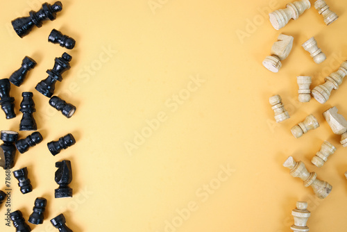 A blank space for text between chess figures isolated over yellow background. Chess business concept, leader and success. World Chess Day. photo