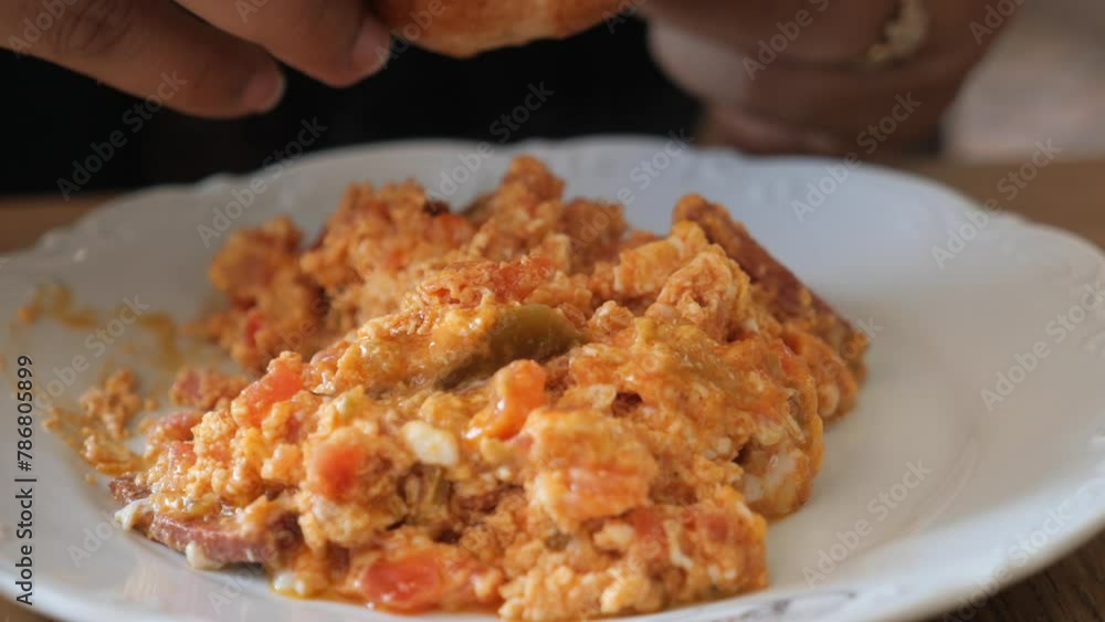 woman eating Turkish Menemen omelet with a bread woman eating Turkish Menemen omelet with a bread