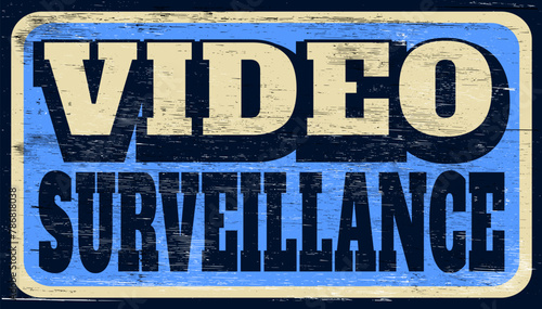 Aged and worn video surveillance sign on wood