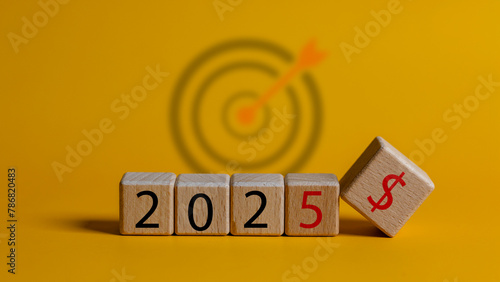 A wooden block with the number 2025 on it is placed on a yellow background