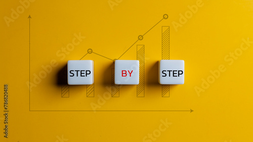 Business concept image with wooden cubes word step by step on wooden cubes. Achievement or progress in business career.