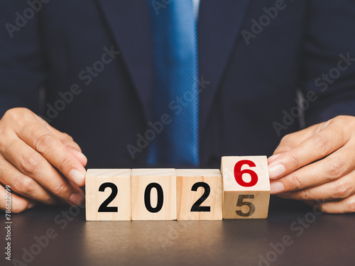 Flipping of 2025 to 2026 on wooden cubes for preparation of new year change.