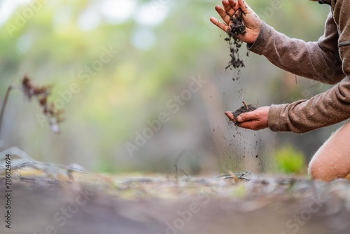 dropping soil in hands feeling texture and soil health. earth in hands
