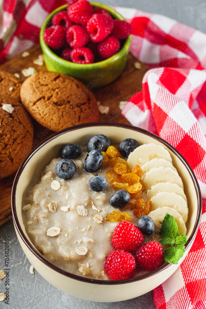 tasty nutritious oatmeal with fruits and berries on a light stone background tasty nutritious oatmeal with fruits and berries on a light stone background