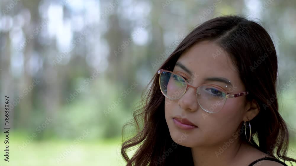 Girl in glasses speaks and nods in slow motion. Conversation of a young woman with long hair blowing in the wind Girl in glasses speaks and nods in slow motion. Conversation of a young woman with long hair blowing in the wind