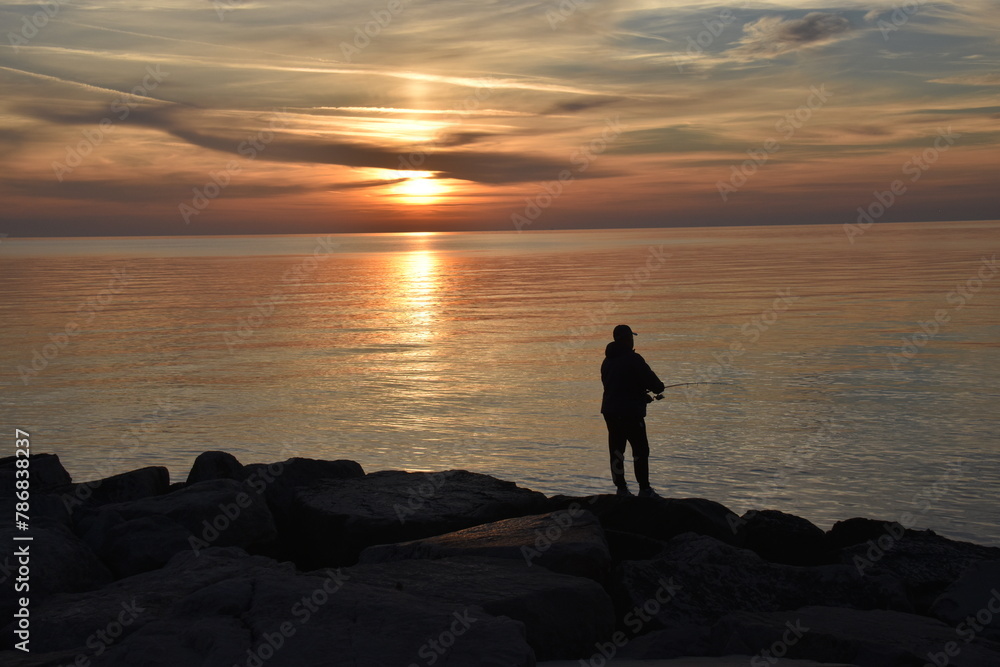 Fisherman at dawn on the rocks