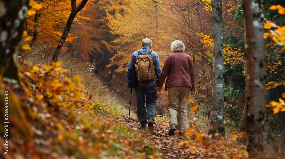 Elderly couple hiking through a forest trail, enjoying the autumn colors