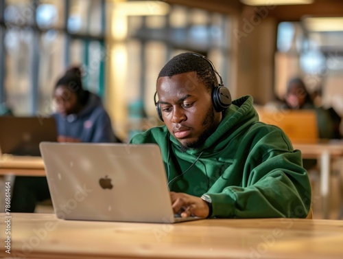 African American Man in green hoodie, autism, sensory sensitive, Focused Freelancer at Work
remote work setting, indoor professional, casual office space
