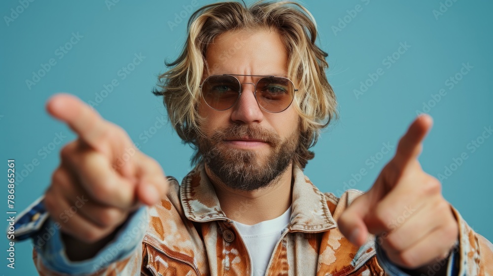 Casual dressed young man pointing to with his finger isolated on studio background Casual dressed young man pointing to with his finger isolated on studio background