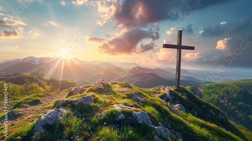 A cross standing on a hilltop illuminated by the setting sun photo