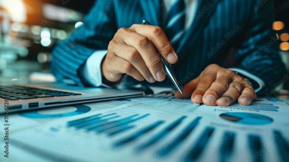 Close-Up of Businessman Analyzing Financial Graphs: Hands Holding Pen Pointing at Charts on Desk, Business Analysis Concept Close-Up of Businessman Analyzing Financial Graphs: Hands Holding Pen Pointing at Charts on Desk, Business Analysis Concept