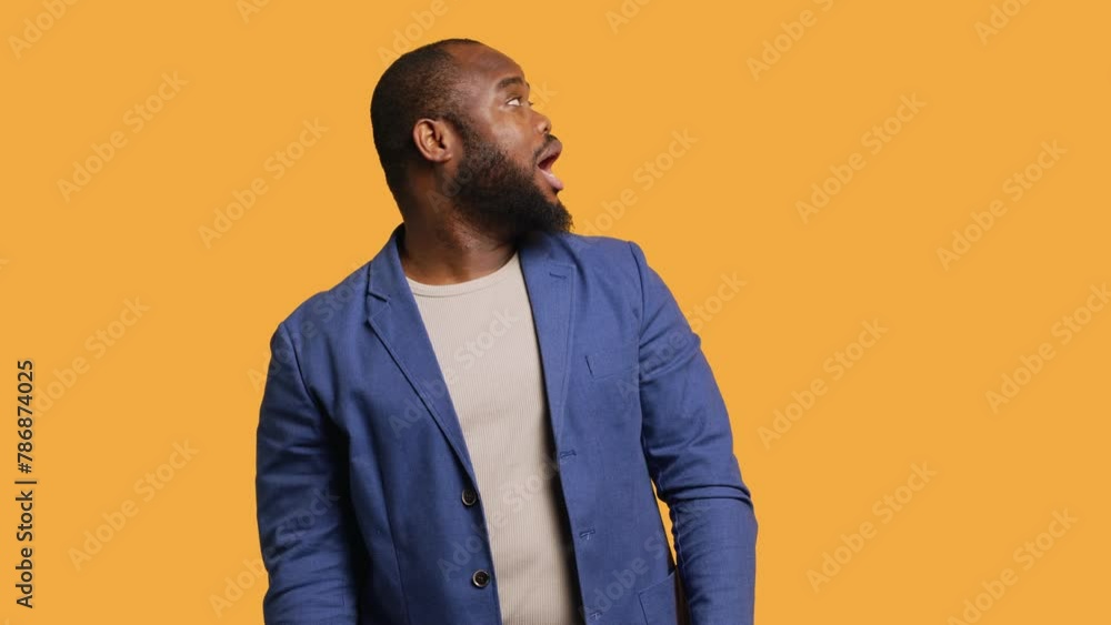Smiling man having friendly conversation with friend sitting off camera, isolated over studio background. BIPOC person having fun catching up with mate, having lively discussion, camera A Smiling man having friendly conversation with friend sitting off camera, isolated over studio background. BIPOC person having fun catching up with mate, having lively discussion, camera A