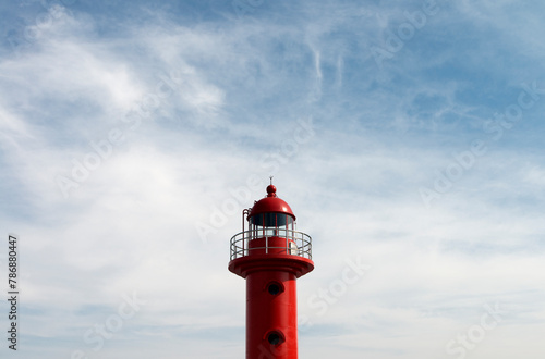 View of the red lighthouse against the cloudy sky