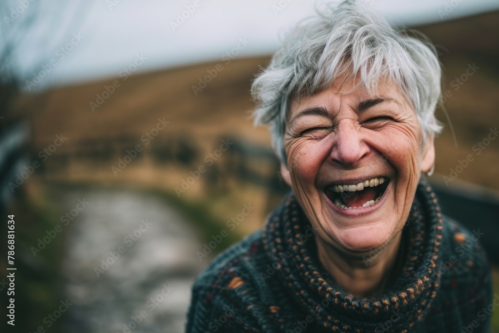 Portrait of a happy senior woman laughing outdoors in the countryside. Portrait of a happy senior woman laughing outdoors in the countryside.