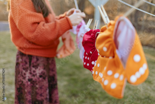 Women hanging cloth diapers on laundry line to dry