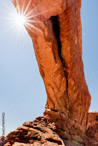 A sunburst at North Window Arch on a sunny day in Arches National Park in Utah, USA.