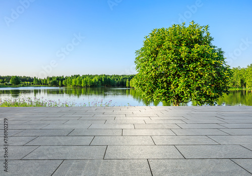 Empty square floor and lake with green tree nature landscape under blue sky