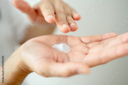 Asian woman hands applying skin cream on hands and arms for healthy skin.