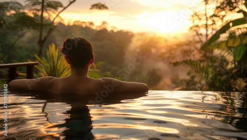 A woman relaxing in an infinity pool enjoying the natural scenery of lush greenery and trees at sunset, feeling calm after her spa experience