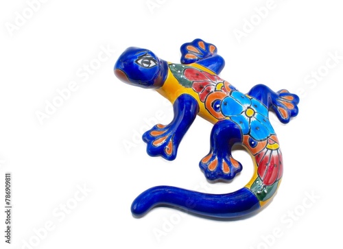 Mexican ceramic pottery of a salamander, gecko or lizard indoor outdoor wall art painted multi colored blue, red, yellow, orange with flower pattern design, isolated on white background photo