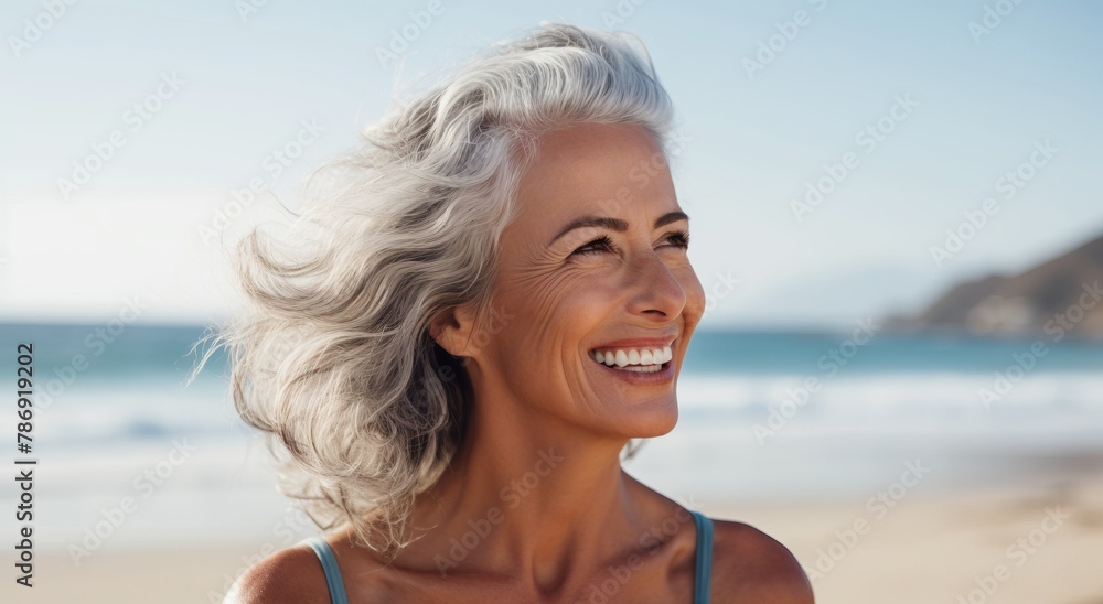 Portrait of a smiling woman wrapped in a blanket on the beach Portrait of a smiling woman wrapped in a blanket on the beach