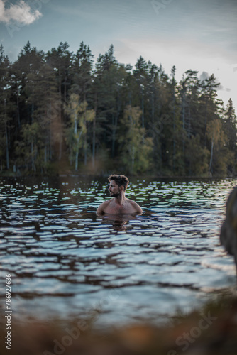 Man bathing in the lake with forest in the background.jpg © Nander PS