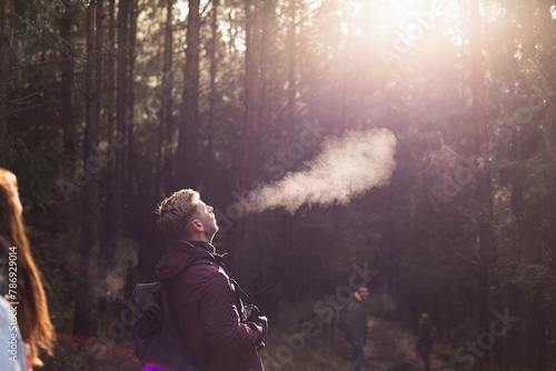 Young man exhaling warm air in cold hike.jpg photo