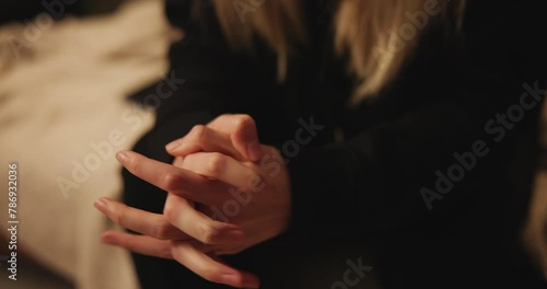Anxiety, hands and nervous woman on a sofa with fear, danger or overwhelmed by mental health crisis at home closeup. Fingers, stress and female person in a living room overthinking, scared or panic