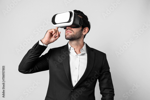 Caucasian business man planning financial plan while using VR goggle. Professional project manager standing and touching VR headset while using visual reality glasses to connect metaverse. Deviation.
