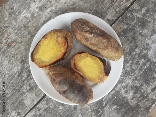 Cilembu sweet potato roasted with honey on a small plate. Wooden table background. Cilembu sweet potato is a local breed of sweet potato cultivar from Cilembu village. photo