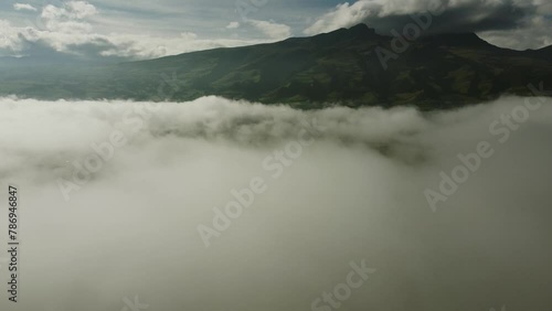 Flying through the clouds to the Rumiñahui volcano. Amazing view of an inactive volcano on a sunny day above the town of Machachi. Pichicnha province, Ecuador