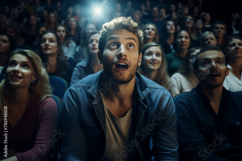 Captivated man in theater with audience under spotlight