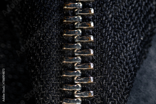 Closed vertical zipper on a black leather bag close-up. Bag zipper in close-up