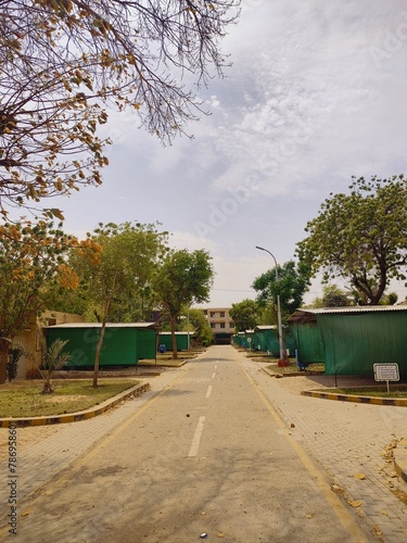 parking area of unilever estate residential area of rahim yar khan, society area road urban city with tree road and cloudy weather photo