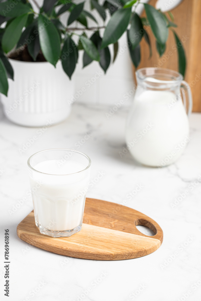 glass and jug of milk in a bright kitchen, dairy products, calcium glass and jug of milk in a bright kitchen, dairy products, calcium