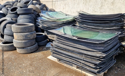 A pile of broken windshields and old car tires