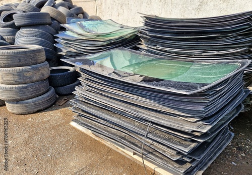 A pile of broken windshields and old car tires