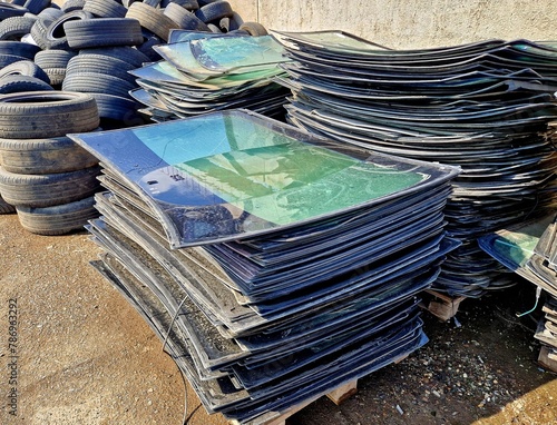 A pile of broken windshields and old car tires