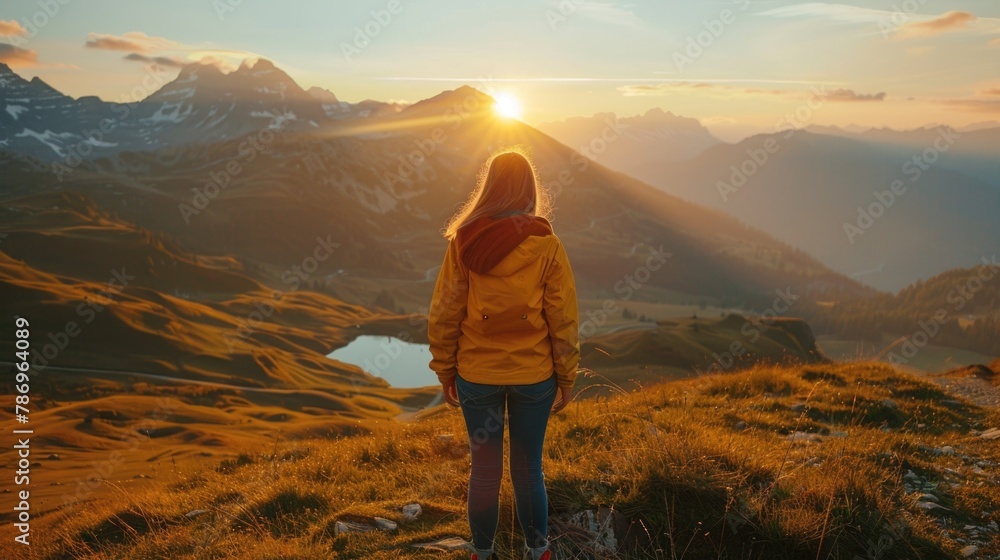 Obraz premium A woman standing on top of a grass-covered hillside. Suitable for nature and outdoor concepts