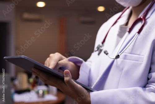 Doctor using or holding ipad in the hospital or clinic, healthcare and medical concept , therapy, tablet, medical, stethoscope, wearing mask