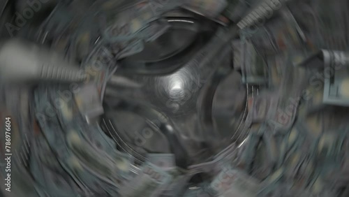 Washing a heap of one hundred dollar bills in washing machine, inside view of drum during spin cycle. Concept of money laundering, financial fraud.