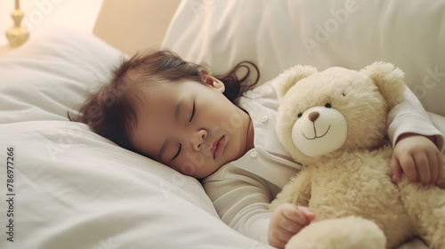 A young child is sleeping with a teddy bear
