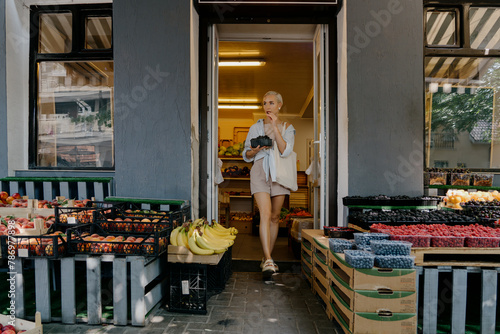 Cuadro en lienzo A small local grocery store provides a selection of fresh produce including fruits, vegetables, and berries in a quaint neighborhood setting