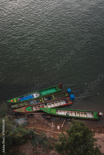 Long fishing boats in Asia docked on the shore © harry